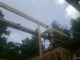 Carpenter setting a ridge beam over a new addition frame — Ice Dam Removal by Roofing Brothers in La Rue