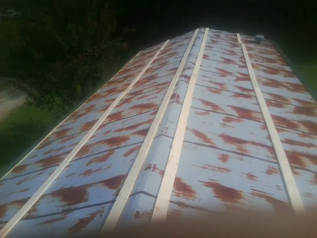 Rusted metal roof panels with new wood purlins before replacement — Storm Damage Roof Repair in La Rue by Roofing Brothers