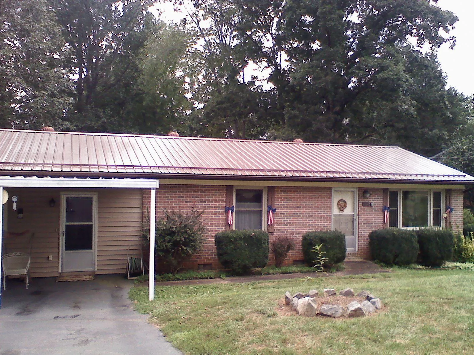 Bronze metal roof and carport on a brick ranch home — Roof Repair work by our crew in La Rue
