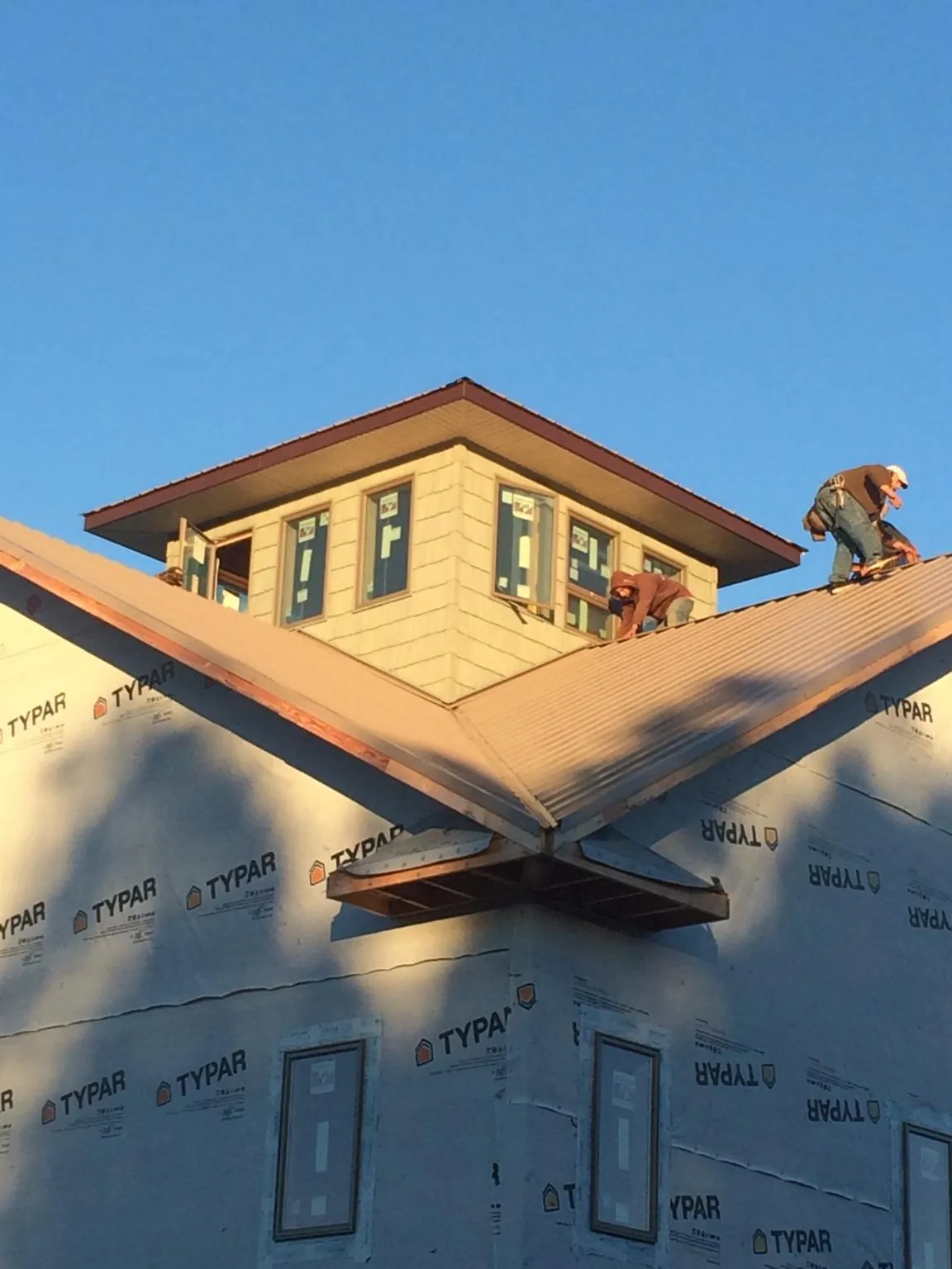 Roofers working around a rooftop cupola on a new metal roof at sunset — Roof Waterproofing in La Rue by Roofing Brothers